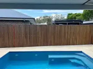 Timber fence along a pool without a green wall installed yet