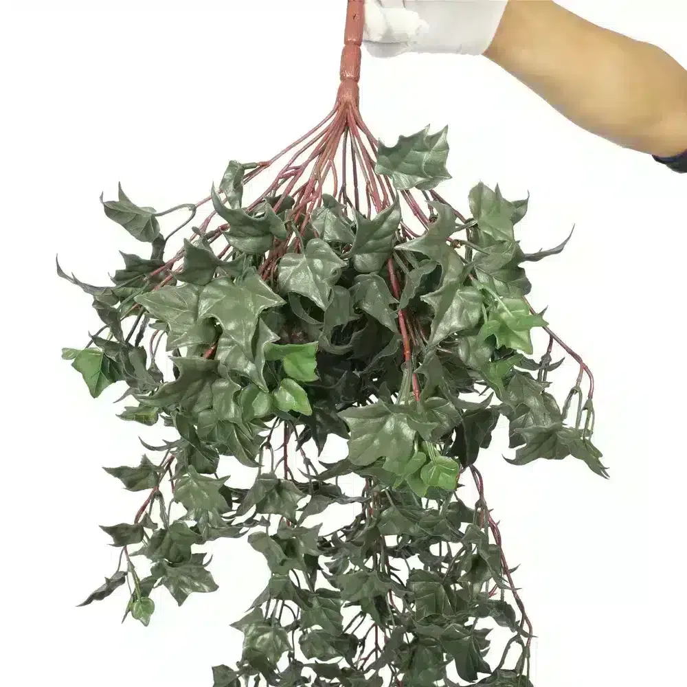 Artificial UV resistant hanging ivy held by hand, showcasing vibrant green leaves and sturdy red stems