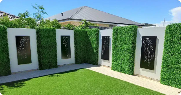 Garden with artificial grass, a paved pathway, and decorative wall panels featuring water features.