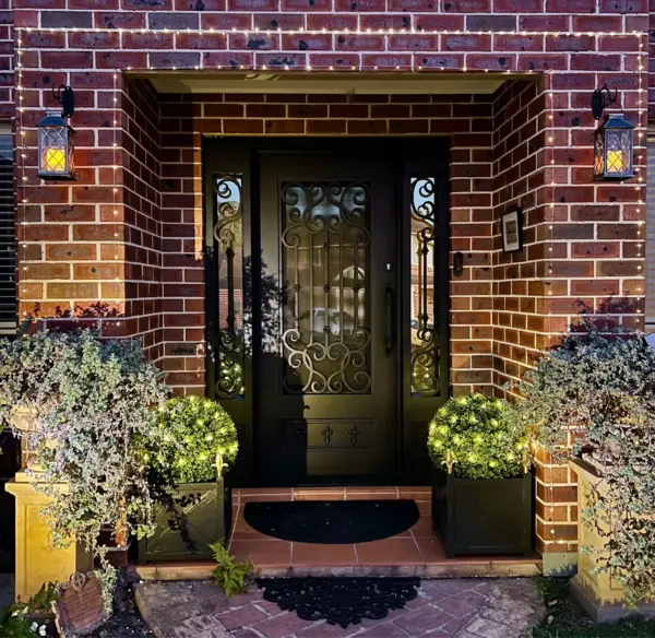 home front door entrance decorated with two artificial topiary balls