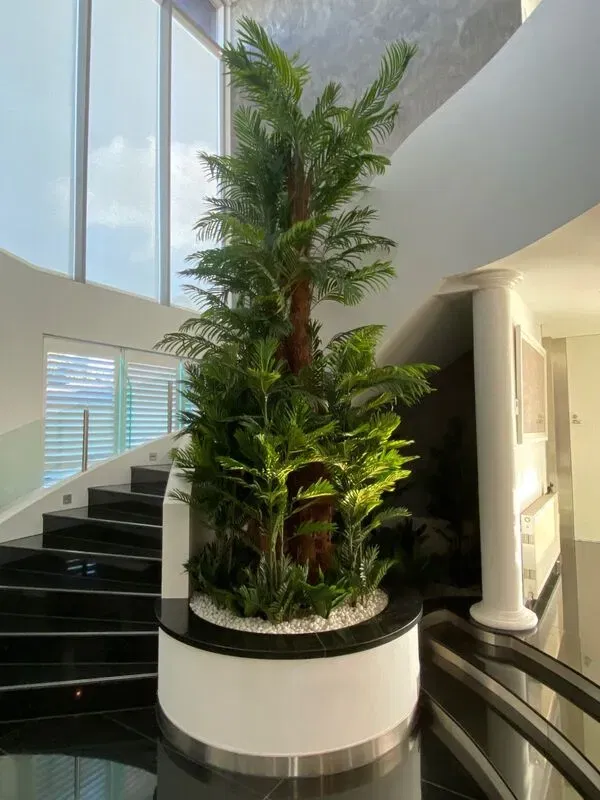 Artificial potted multi trunk fan palm near the stairs