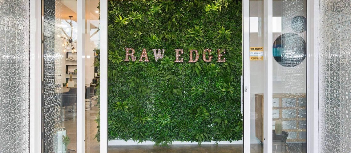 raw edge salon text in artificial green wall
